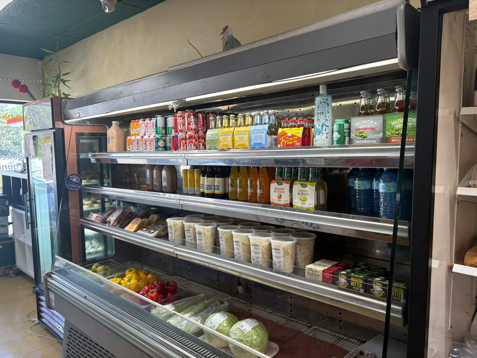 Shelves of local products and a refrigerated display inside the shop